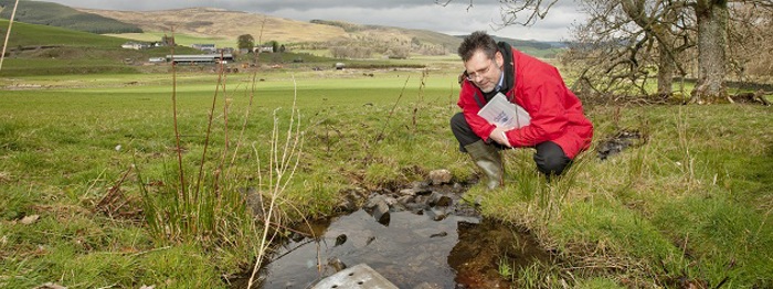 A member of staff looking at a water source