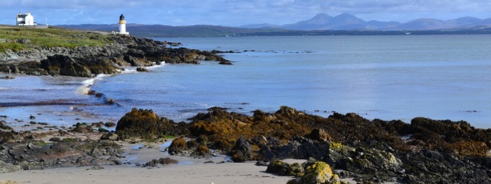 View of a beach with a pier and lighthouse
