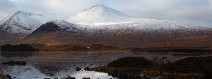 View of a Loch Rannoch with hills in the background with snow on top