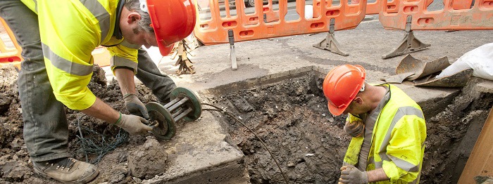 Two men digging a hole