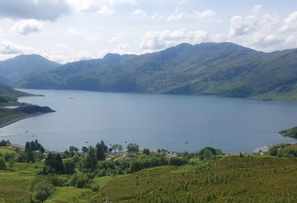 A body of water with hills in the background