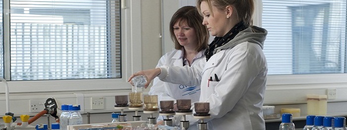 A member of DWQR watching a member of Scottish Water's Laboratory Staff carrying out their analysis